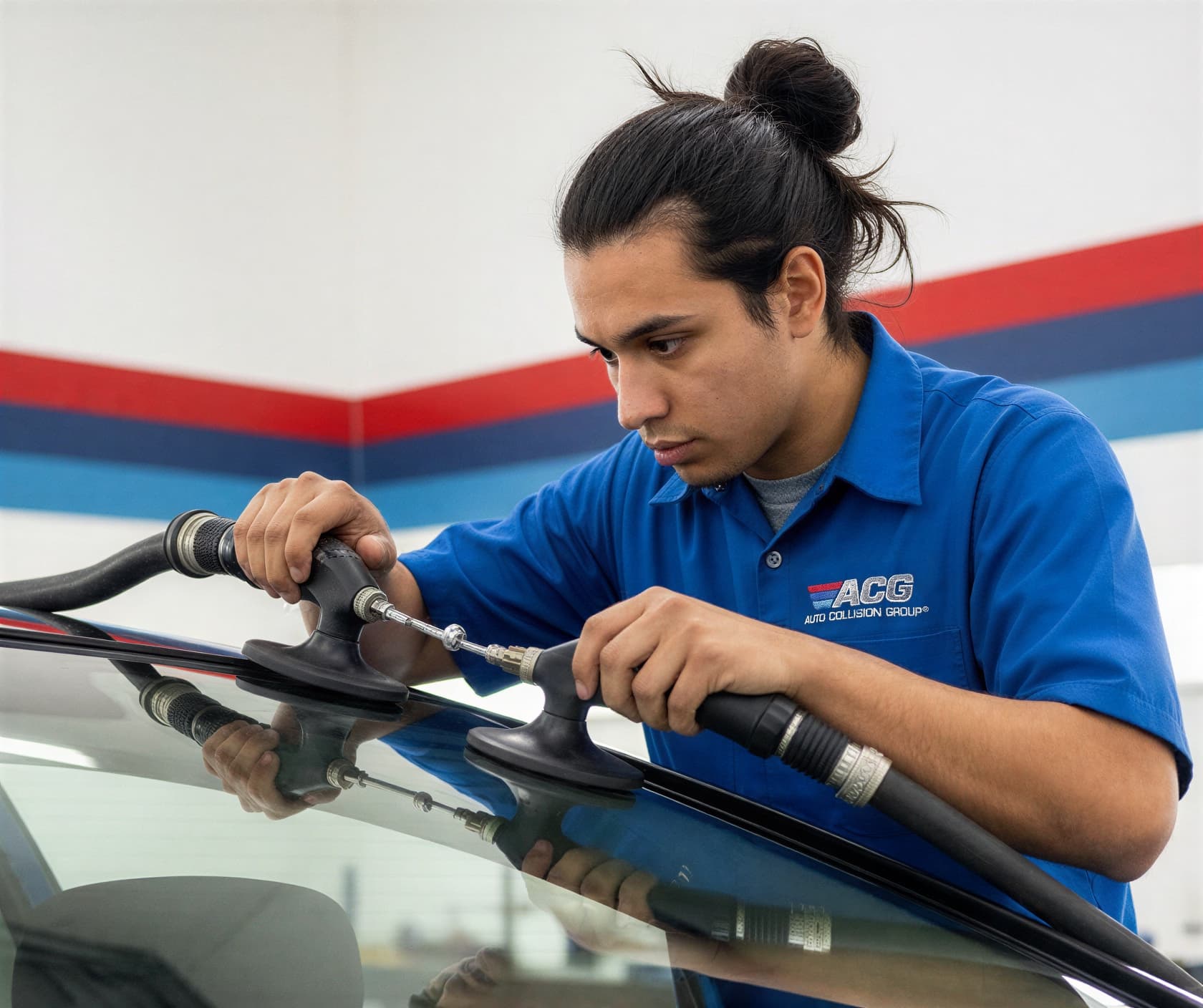 Certified technician performing auto glass and windshield replacement at Auto Collision Group Covina